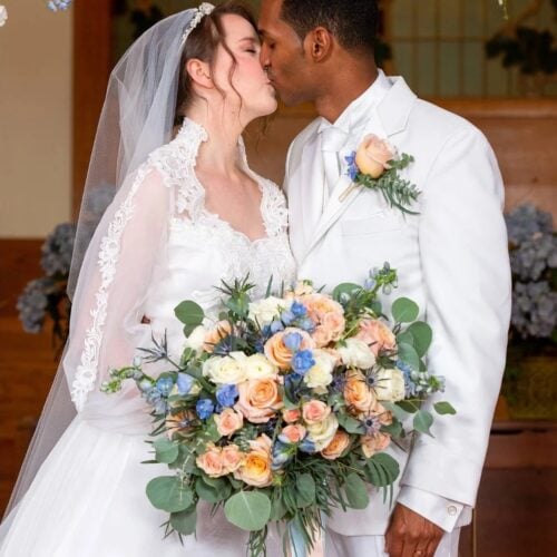 groom in white madison tuxedo rental with bride