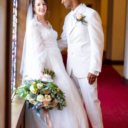 groom in white madison tuxedo rental with bride
