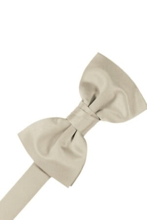 Beige fabric bow tied at its center with a long ribbon extending to the left, on a white background