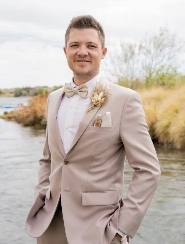 Groom smiling wearing tan suit rental by NTR