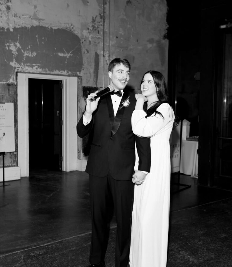 groom giving speech at wedding in black tuxedo rental