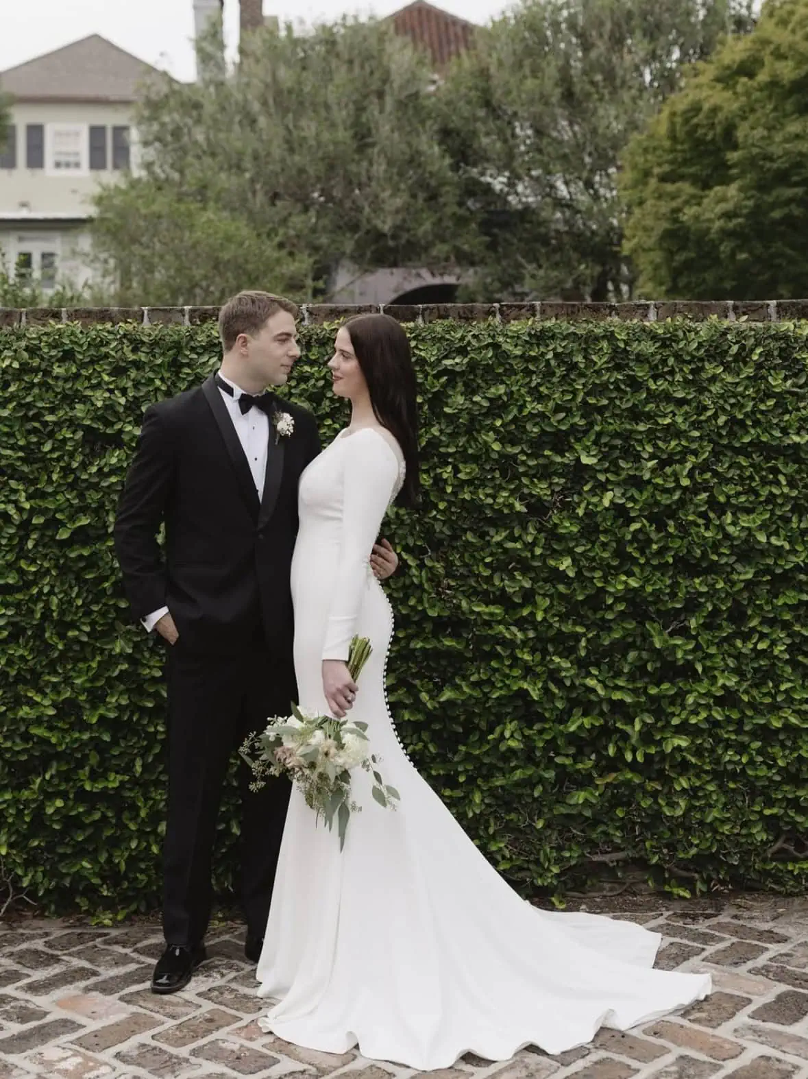 groom in black shawl tuxedo with bride outside