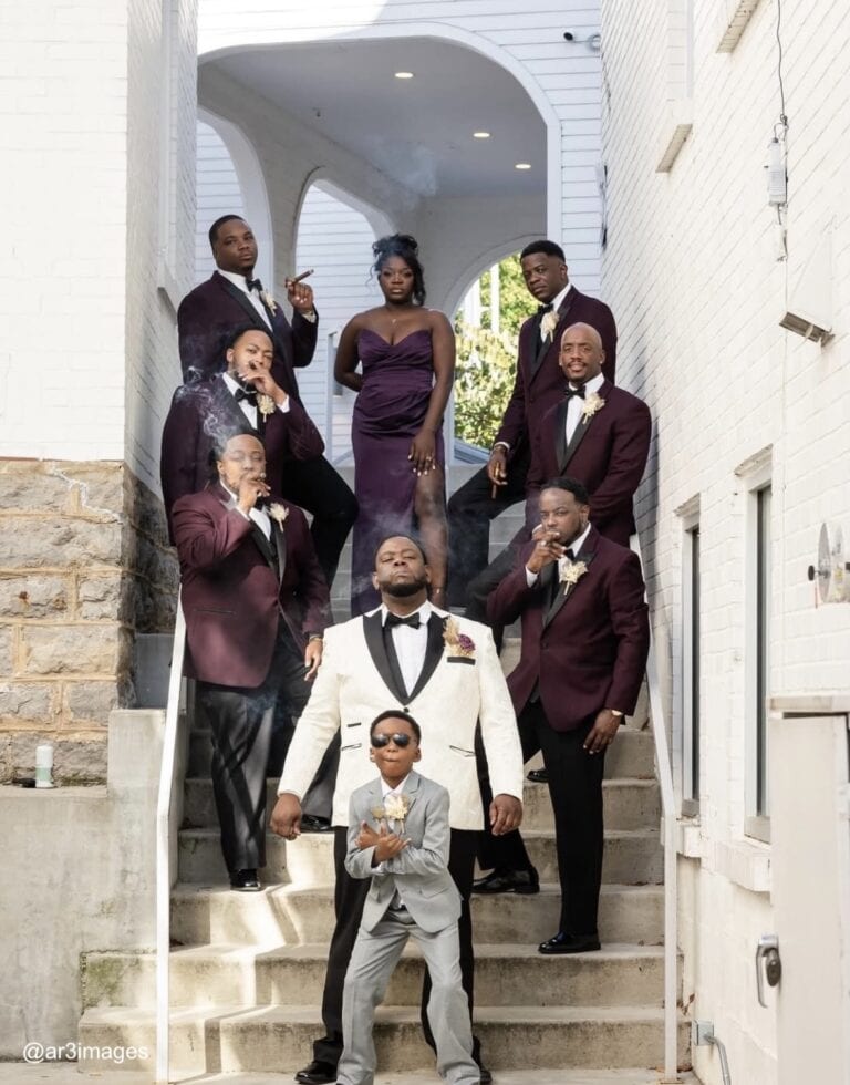 Groom and groomsmen in tuxedo rentals posing on stairway