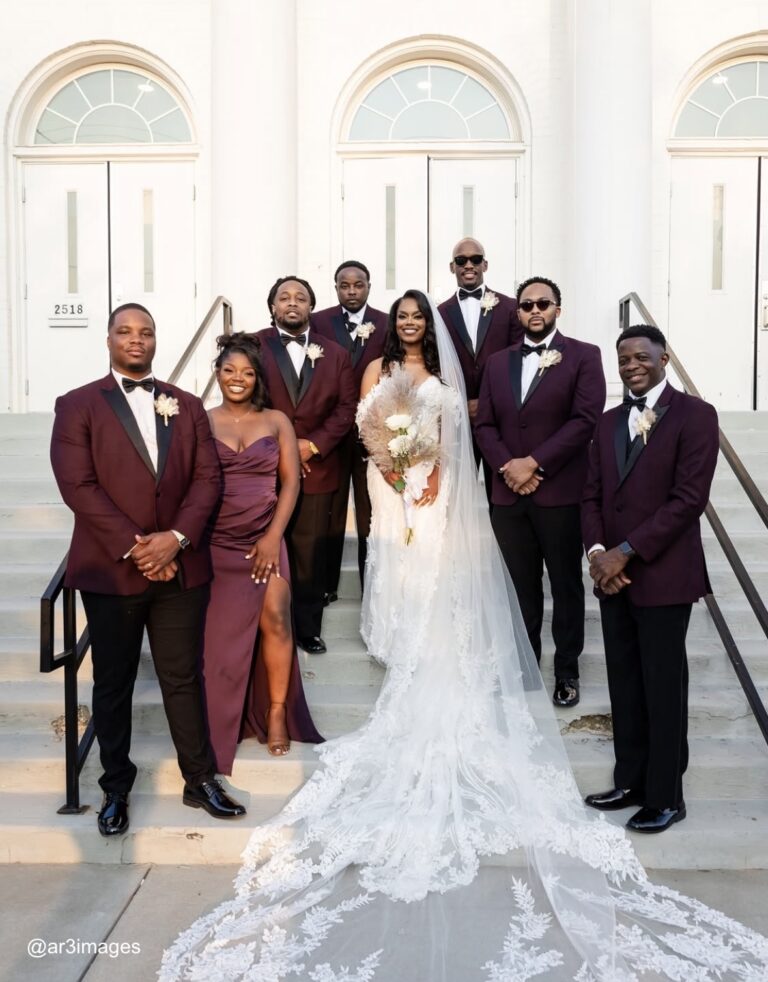 bride and groomsmen in tuxedo rentals posing on stairway
