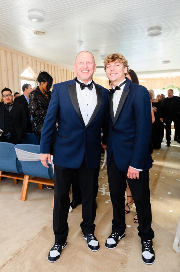 two men wearing navy and black tuxedo rentals at wedding