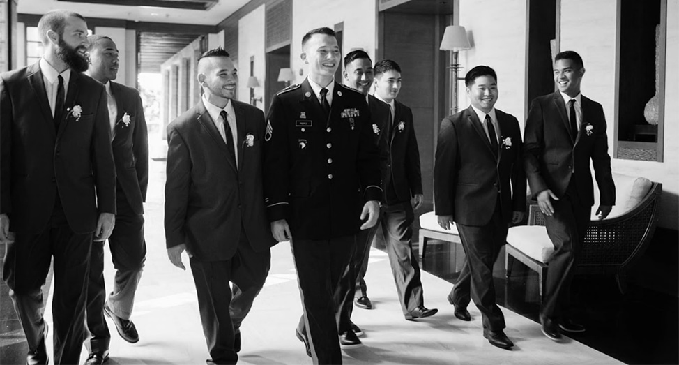 Groomsmen walking down hallway in tuxedos