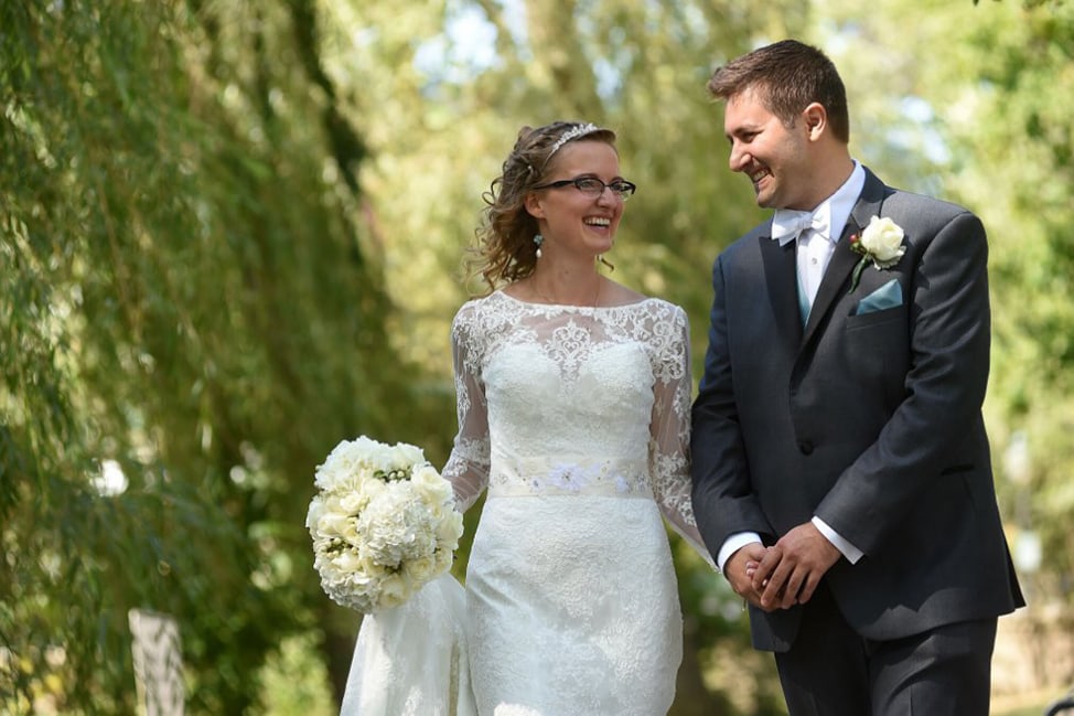 Bride and Groom walk through wooded area