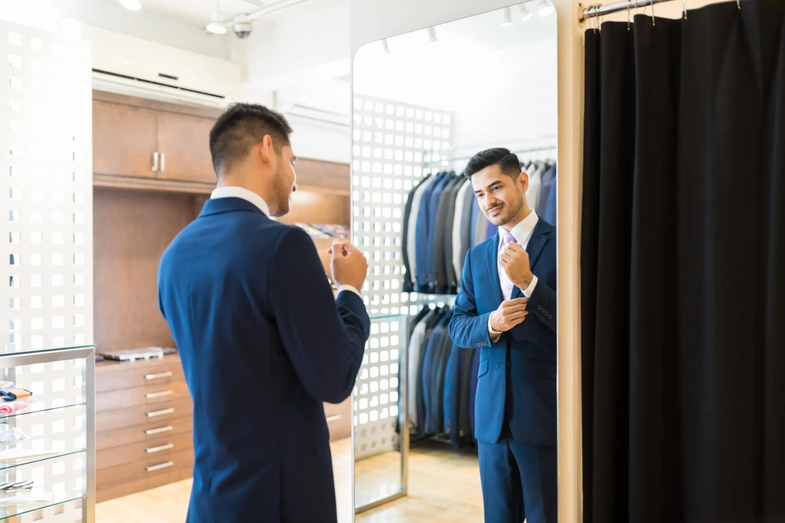 man trying on his tuxedo rental at home