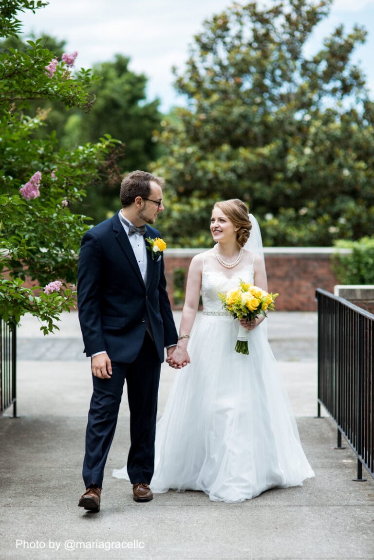 a grooms wearing a navy blue suit rental walking outside after getting married