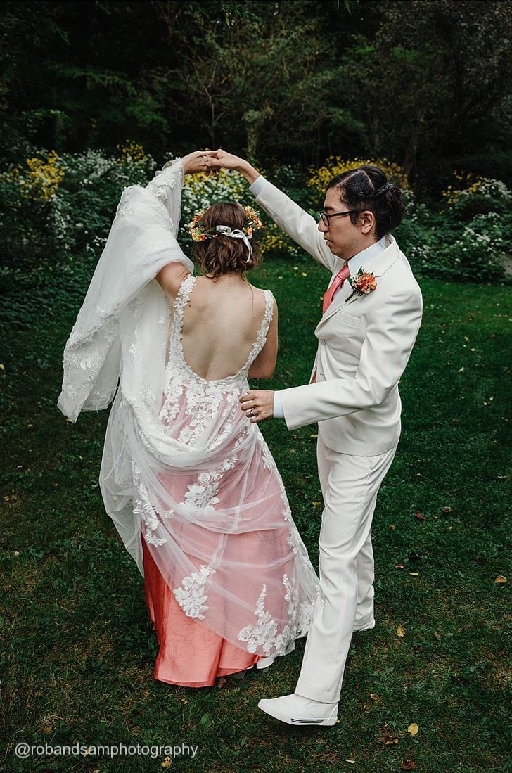 a groom wearing a white tuxedo rental spinning his bride