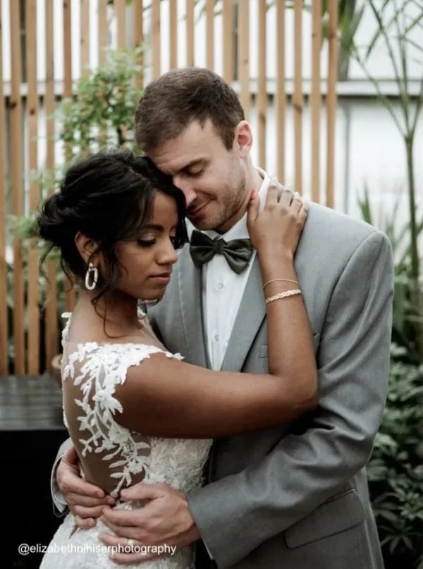 man wearing a heather gray suit rental posing with bride