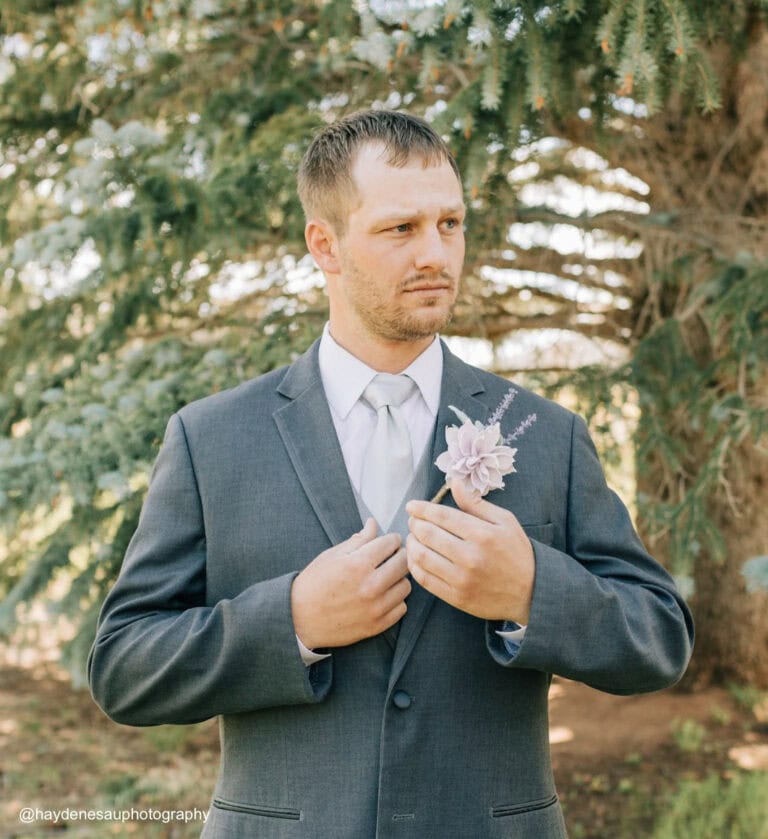 a man wearing a steel grey tuxedo rental outside on wedding day