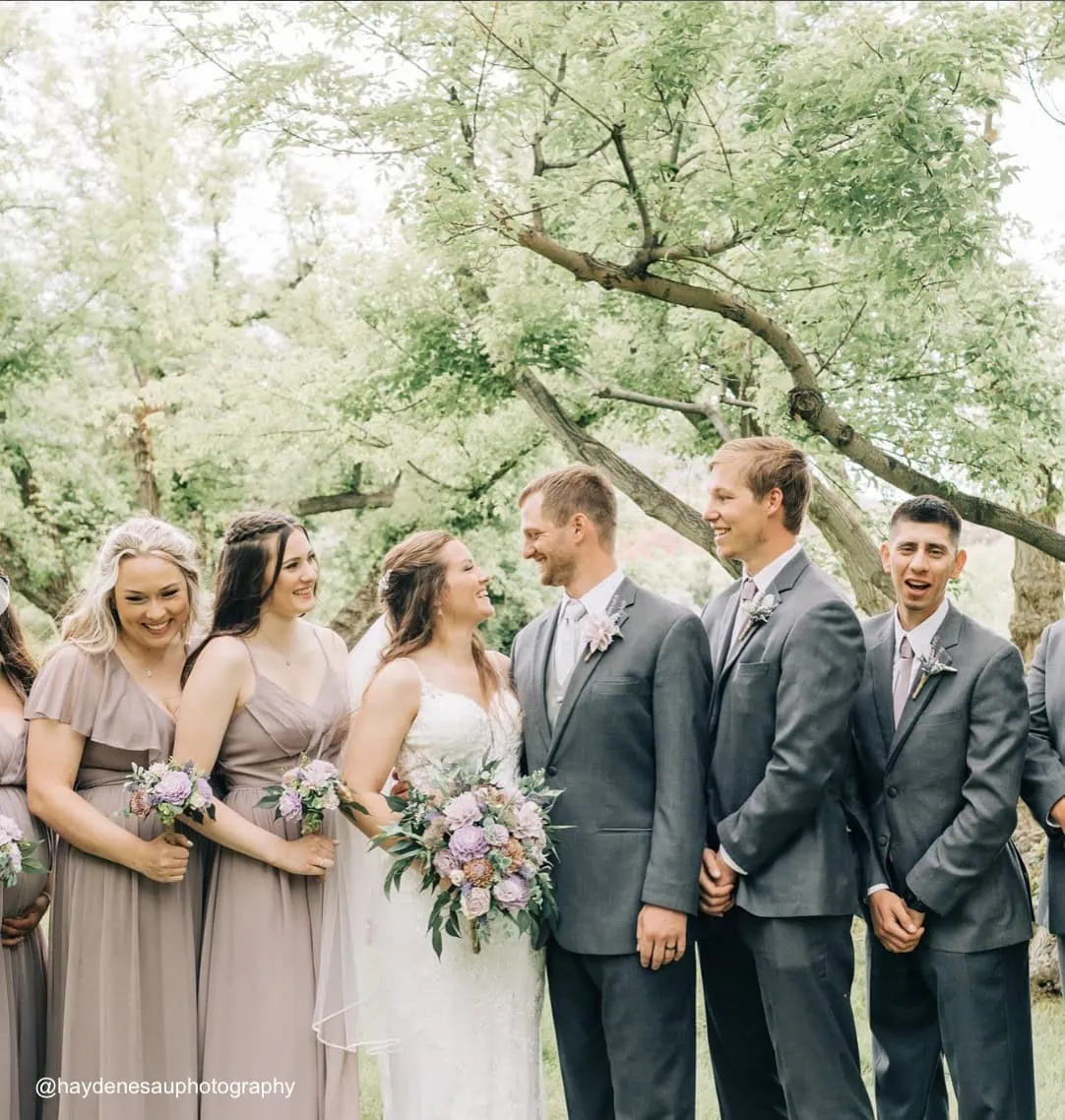 bride and groom posing outdoors with their wedding party