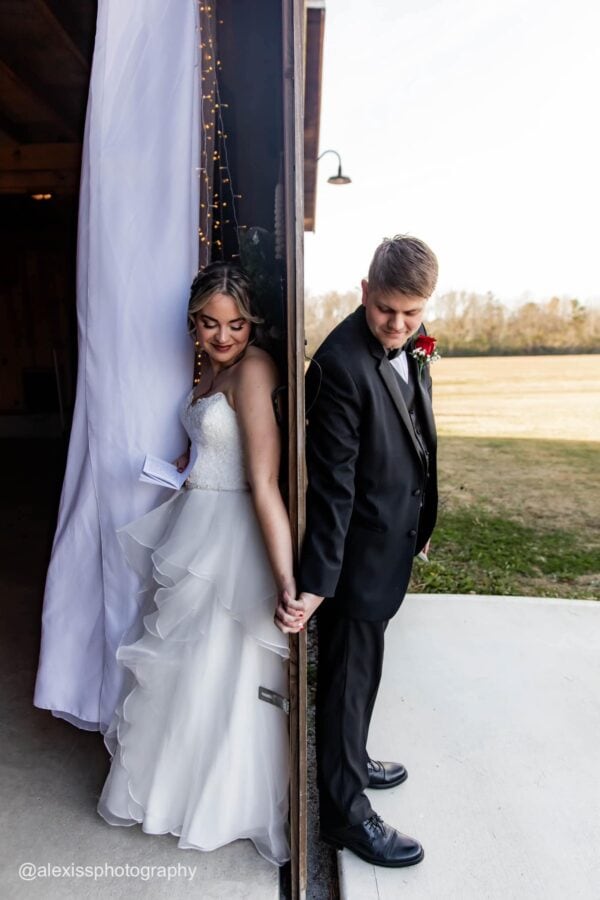 groom wearing a black tuxedo rental posing with bride before wedding