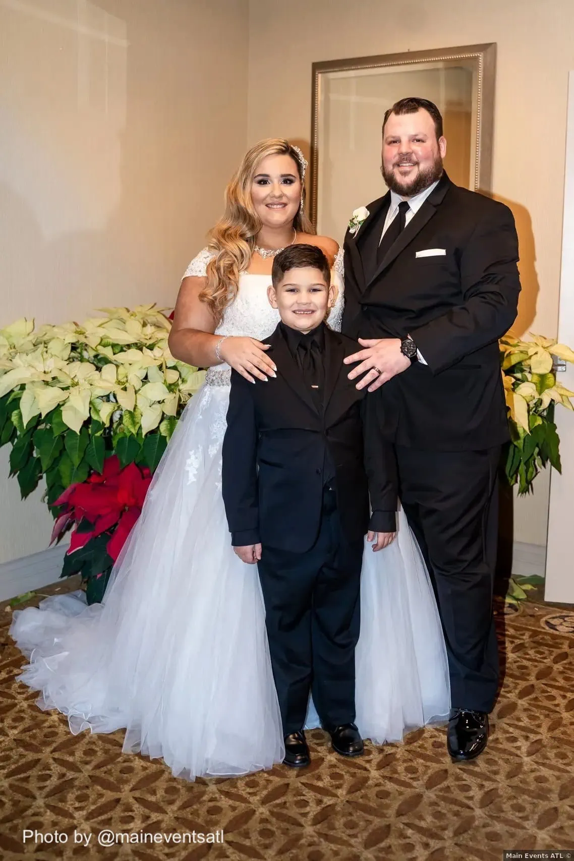 wedding couple standing with ringbearer at wedding