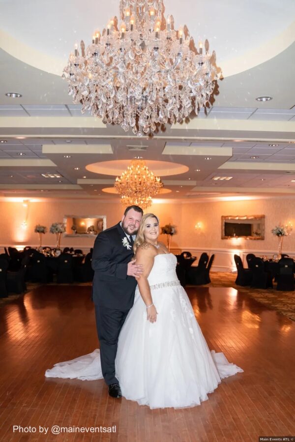 groom wearing a black tuxedo rental at wedding with bride