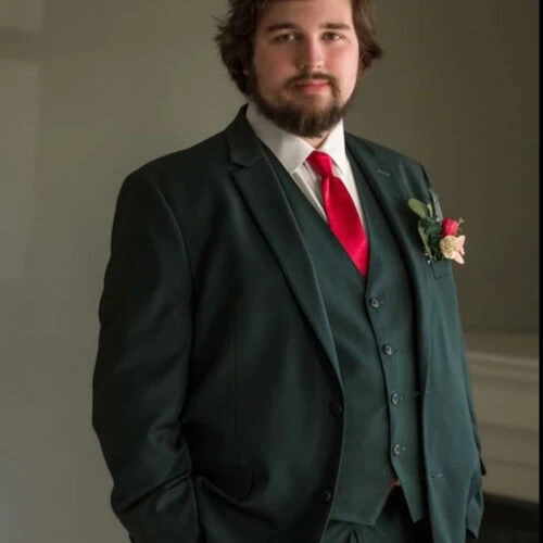 groom wearing green suit rental with red tie