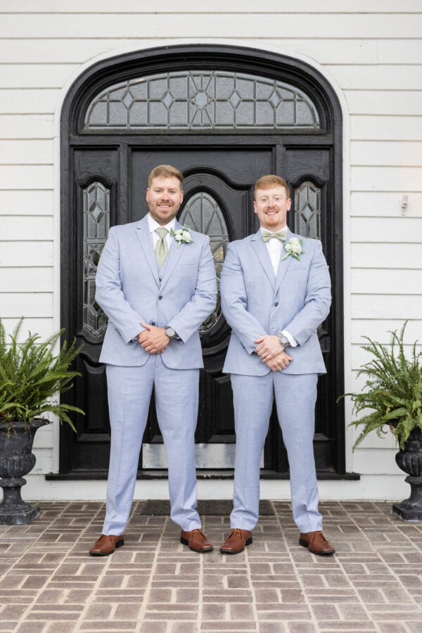 9CA2525A-448E-4266-B9FD-623EE29CF22B | National Tuxedo Rentals groom and best man standing in front of doorway