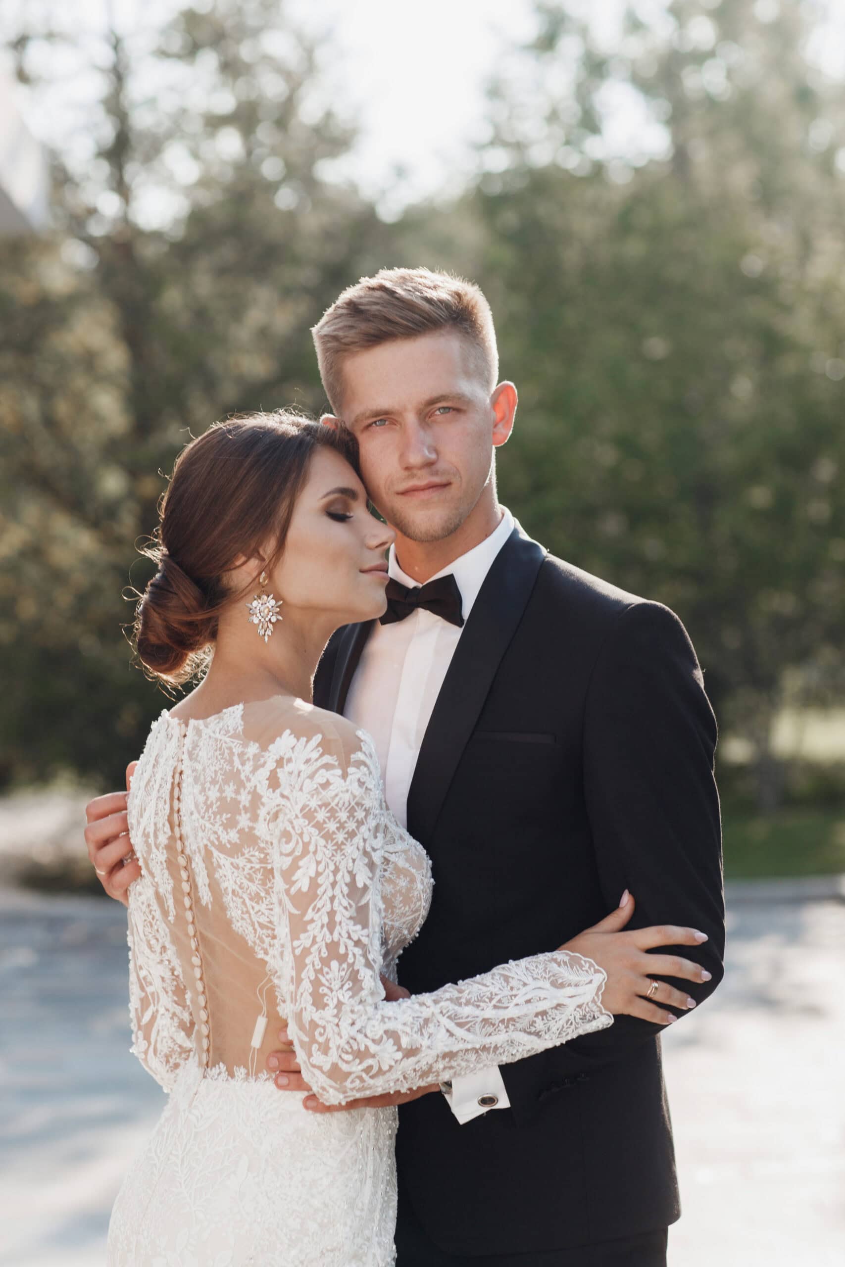 man dressed in a black tie tuxedo with his beautiful bride