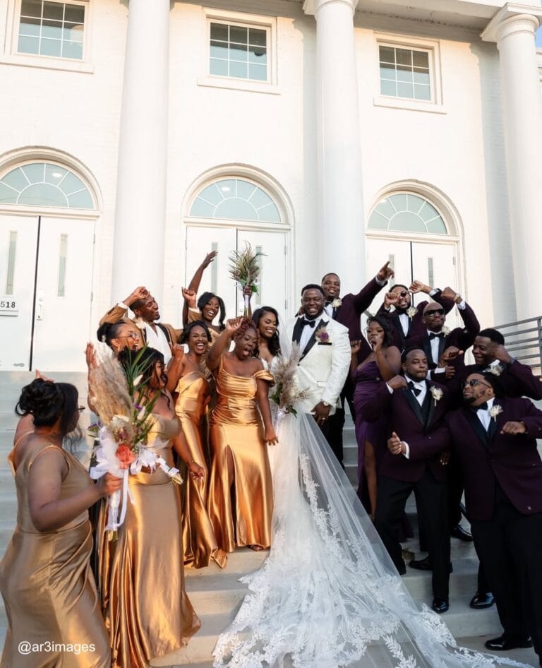 wedding party on stairs outside of venue