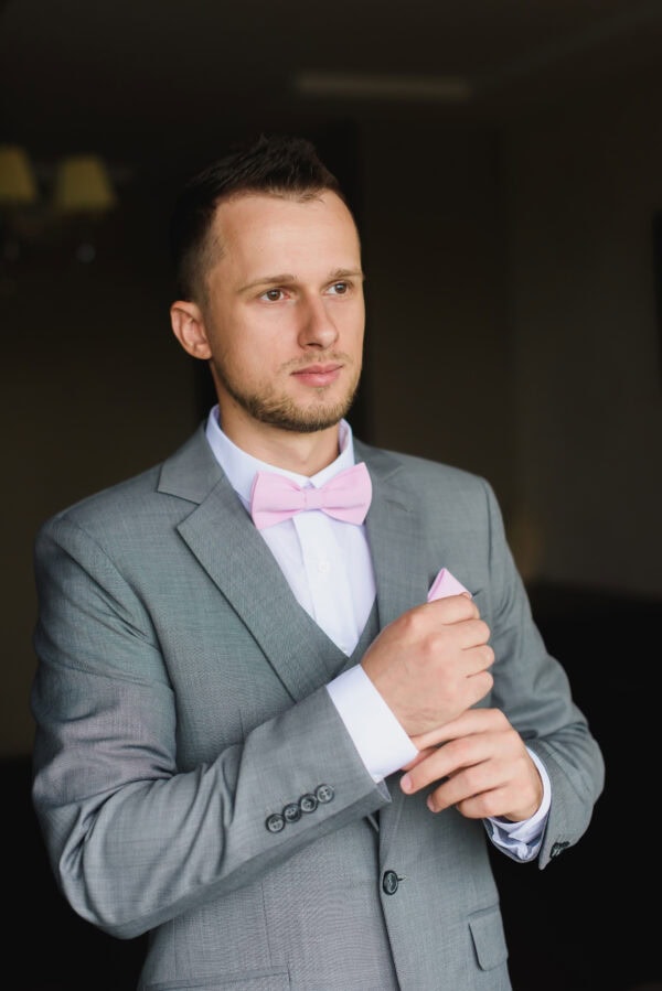 man in a heather grey suit rental and pink bowtie
