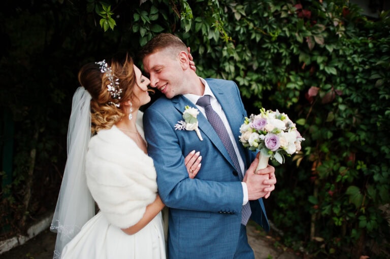 man in blue suit rental with bride outside