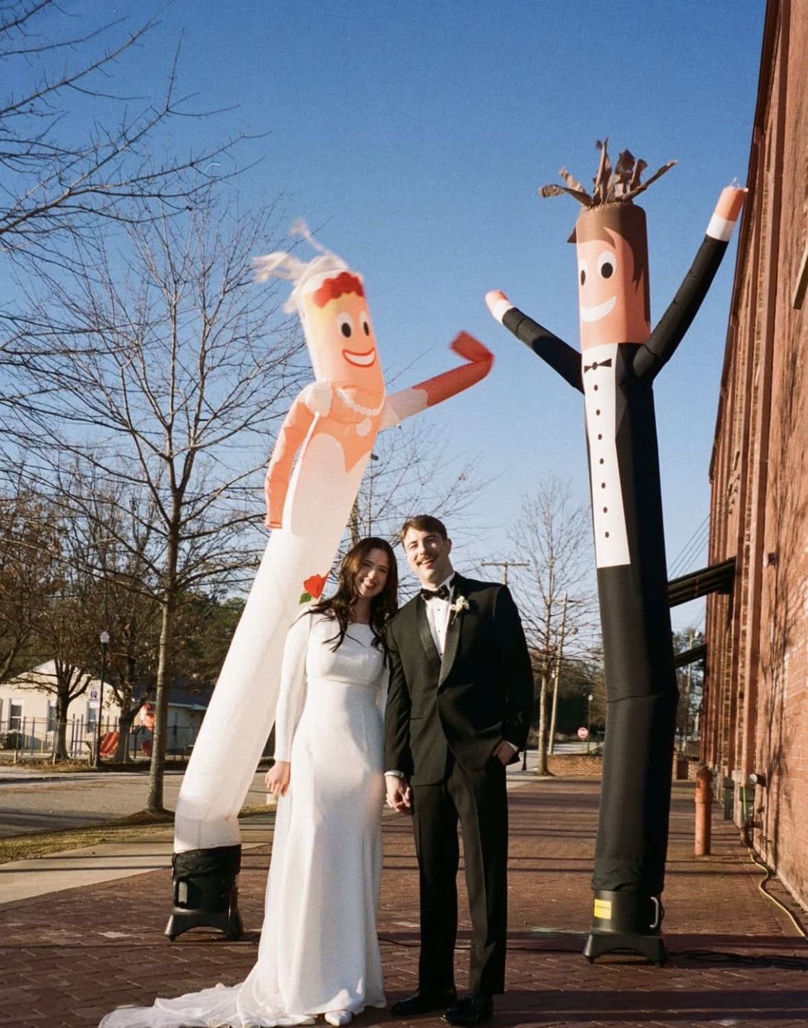 bride and groom standing infront of inflatable bride and groom