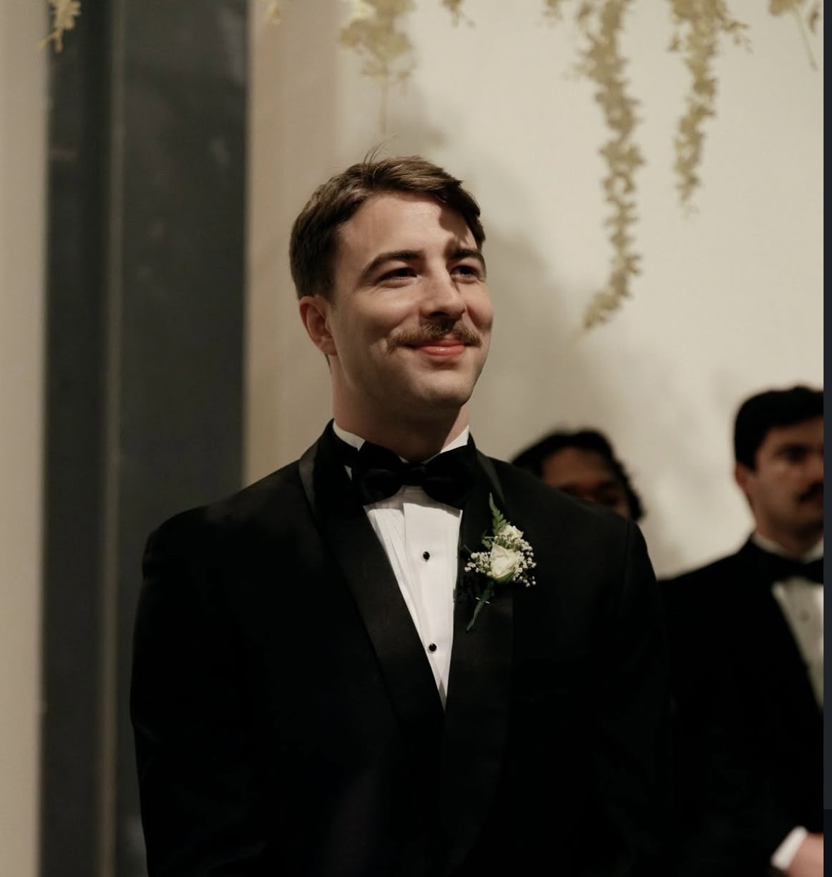 smiling groom wearing black tuxedo rental