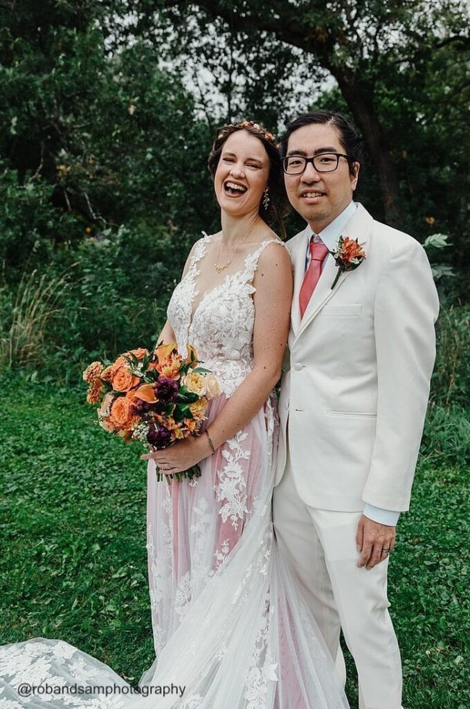 happy bride and groom smiling outdoors