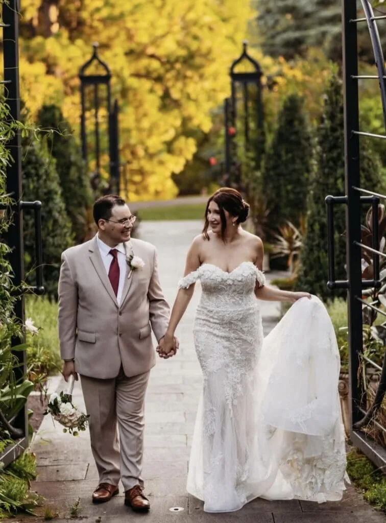 groom in a tan suit rental with bride at outdoor fall wedding