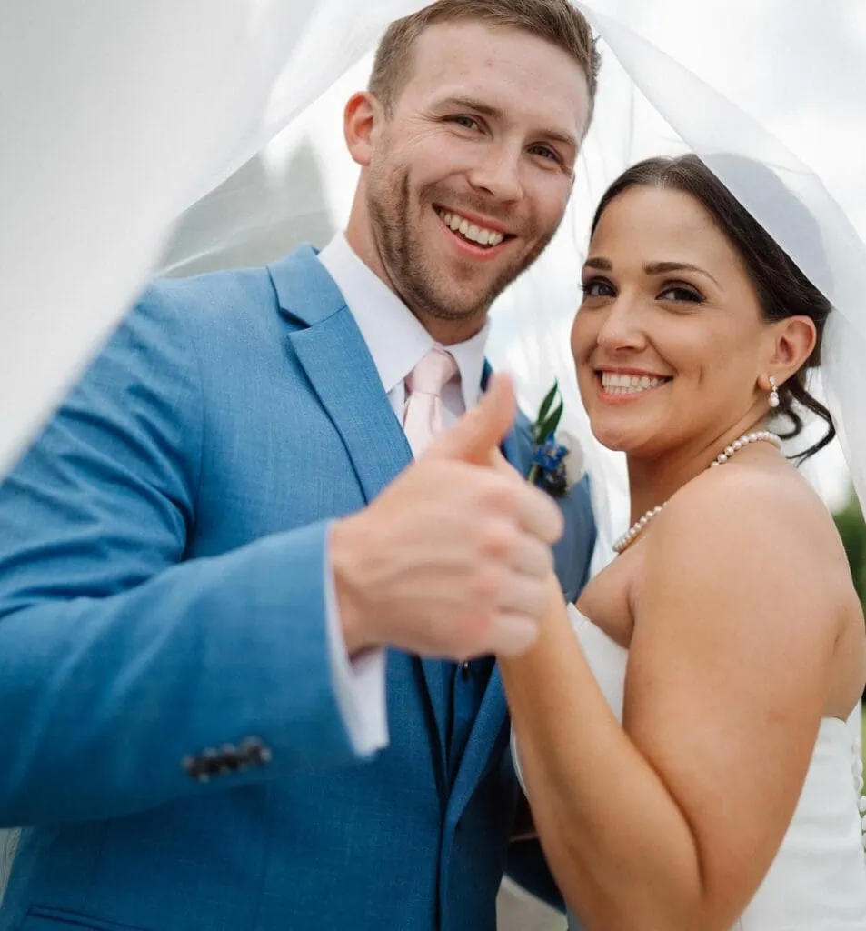 groom in marine blue suit under brides veil