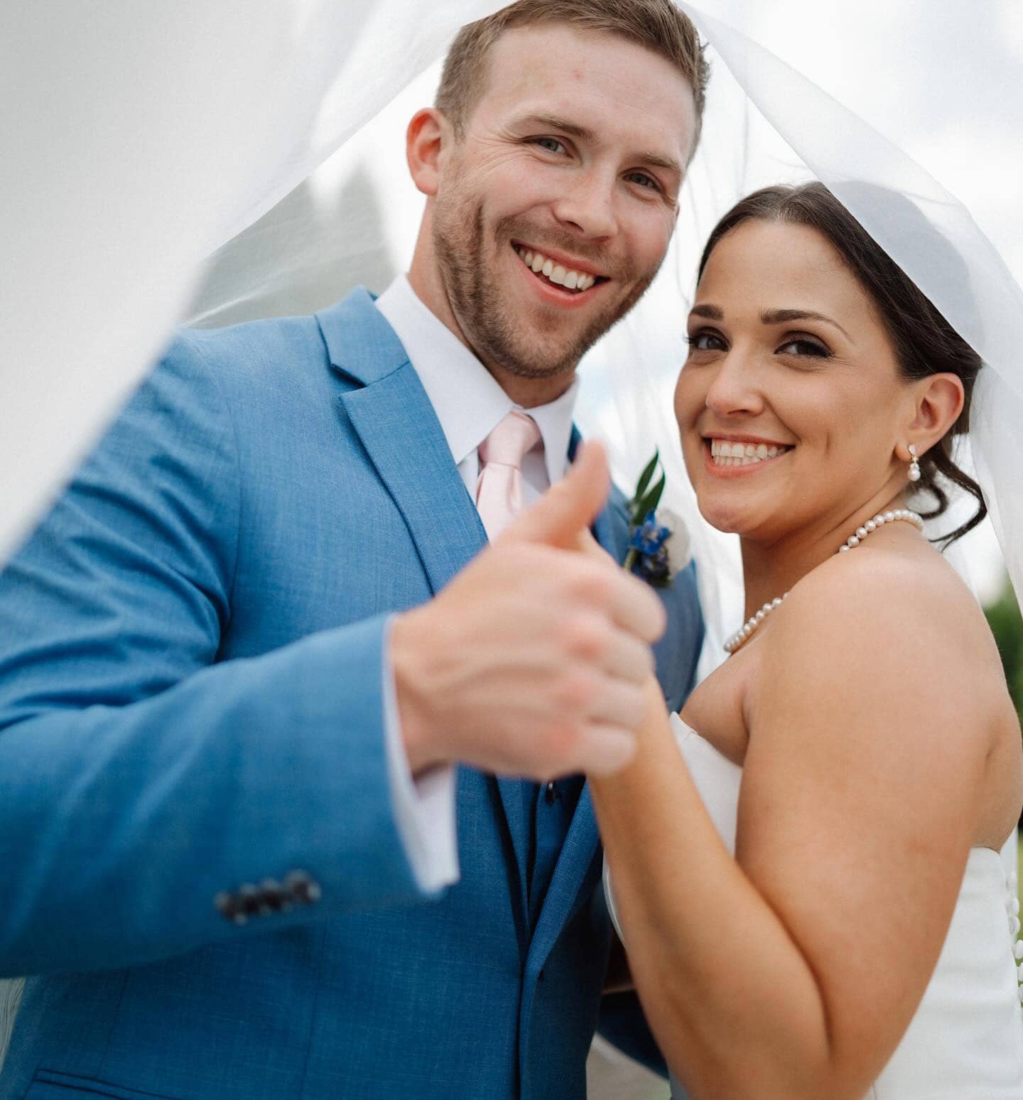 groom in marine blue suit under brides veil