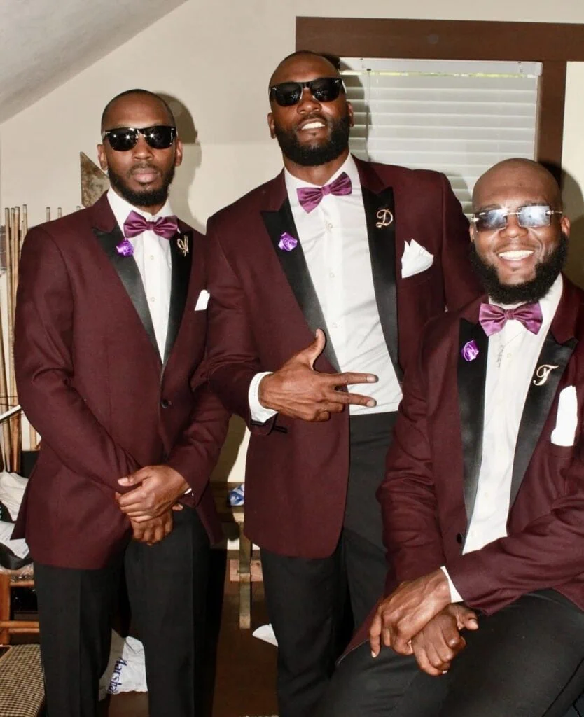 three men wearing maroon tuxedos