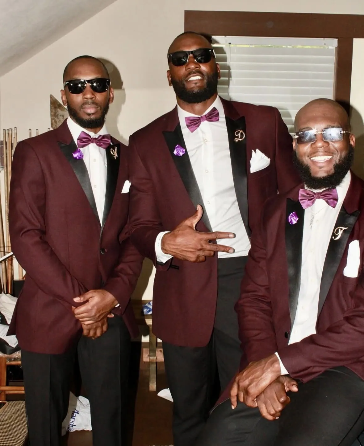 three men wearing maroon tuxedos