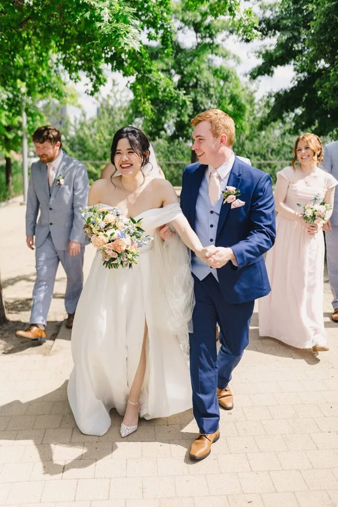 bride and groom walking with wedding party