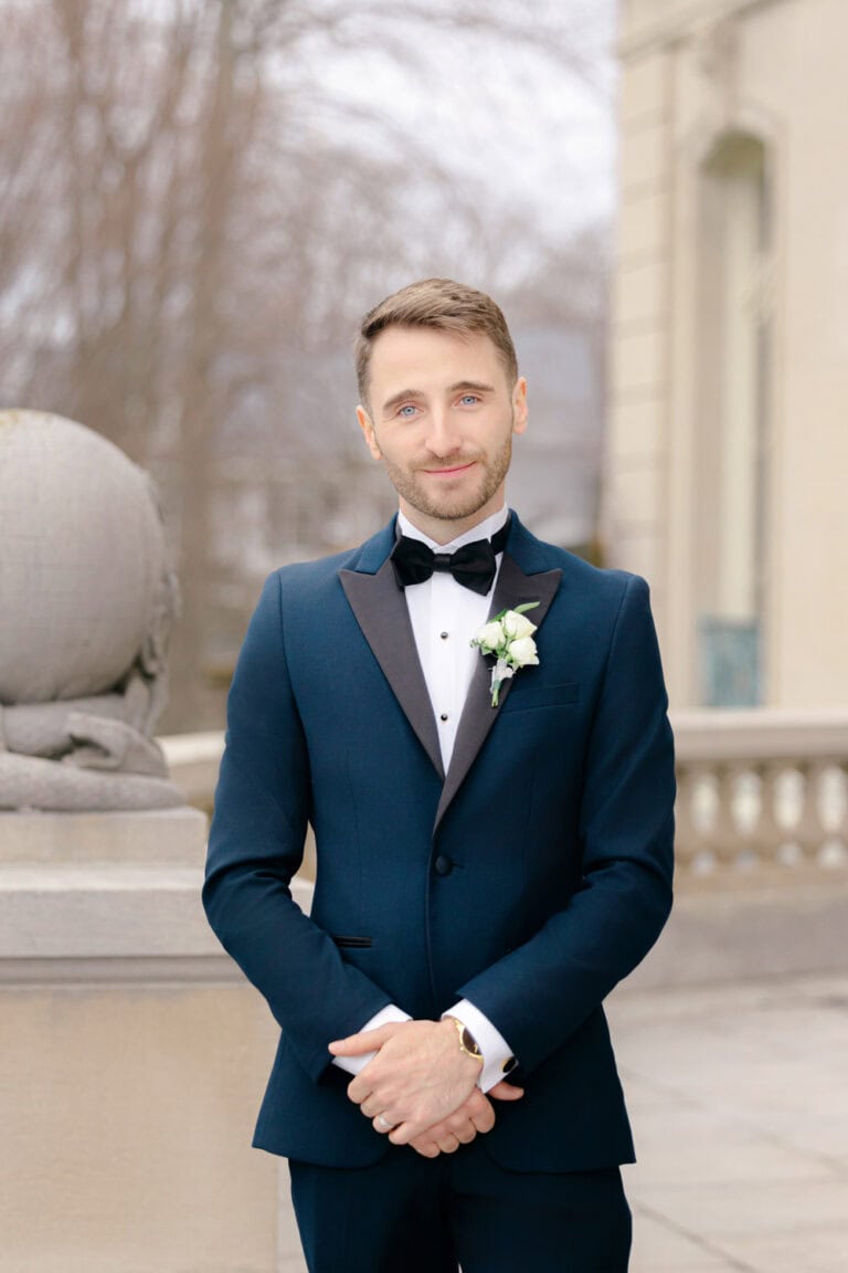 groom wearing a navy tuxedo rental with black peak lapel