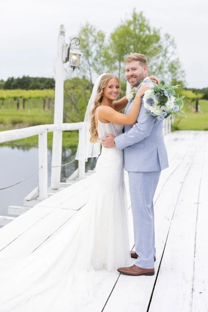 bride and groom posing for a photo on bridge