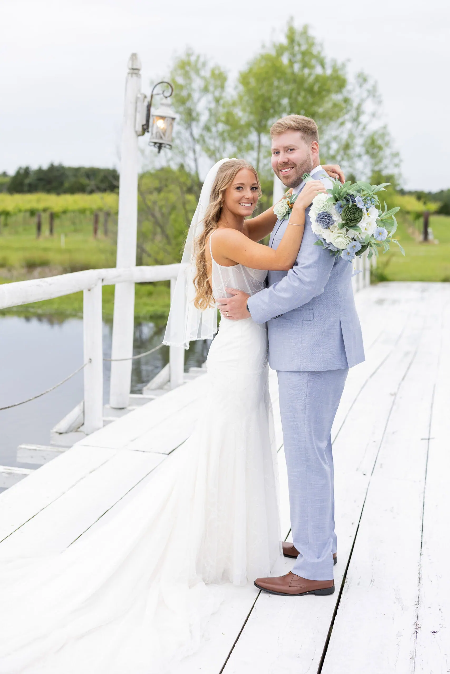 bride and groom posing for a photo on bridge