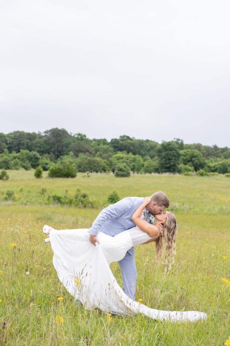 bride and groom in field posing