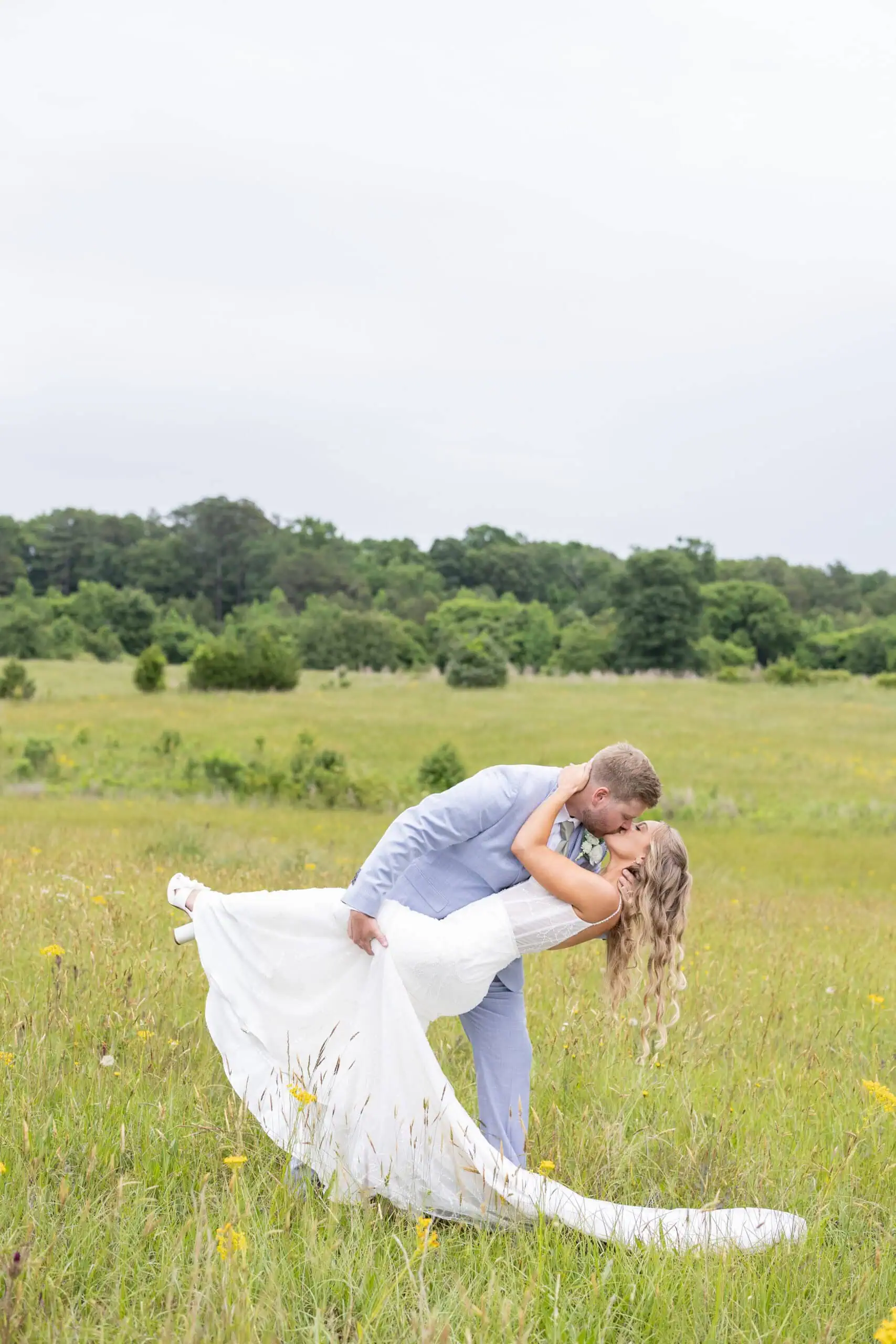 bride and groom in field posing