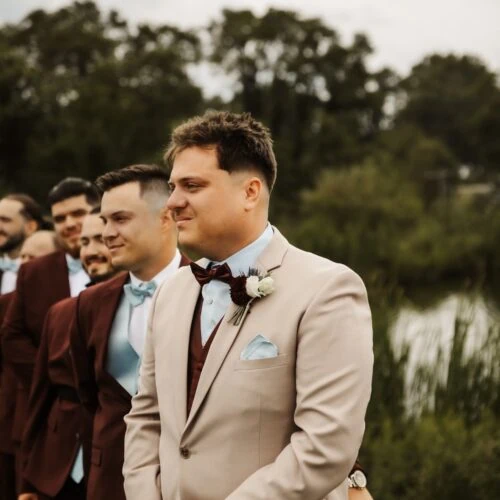 groom wearing tan suit with blue dress shirt