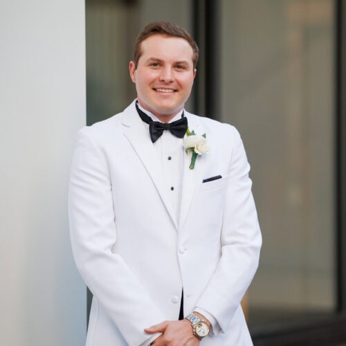 groom wearing white tuxedo rental