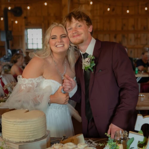 groom wearing burgundy suit with bride