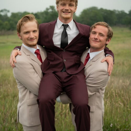 grooms wearing burgundy suit with groomsmen wearing tan
