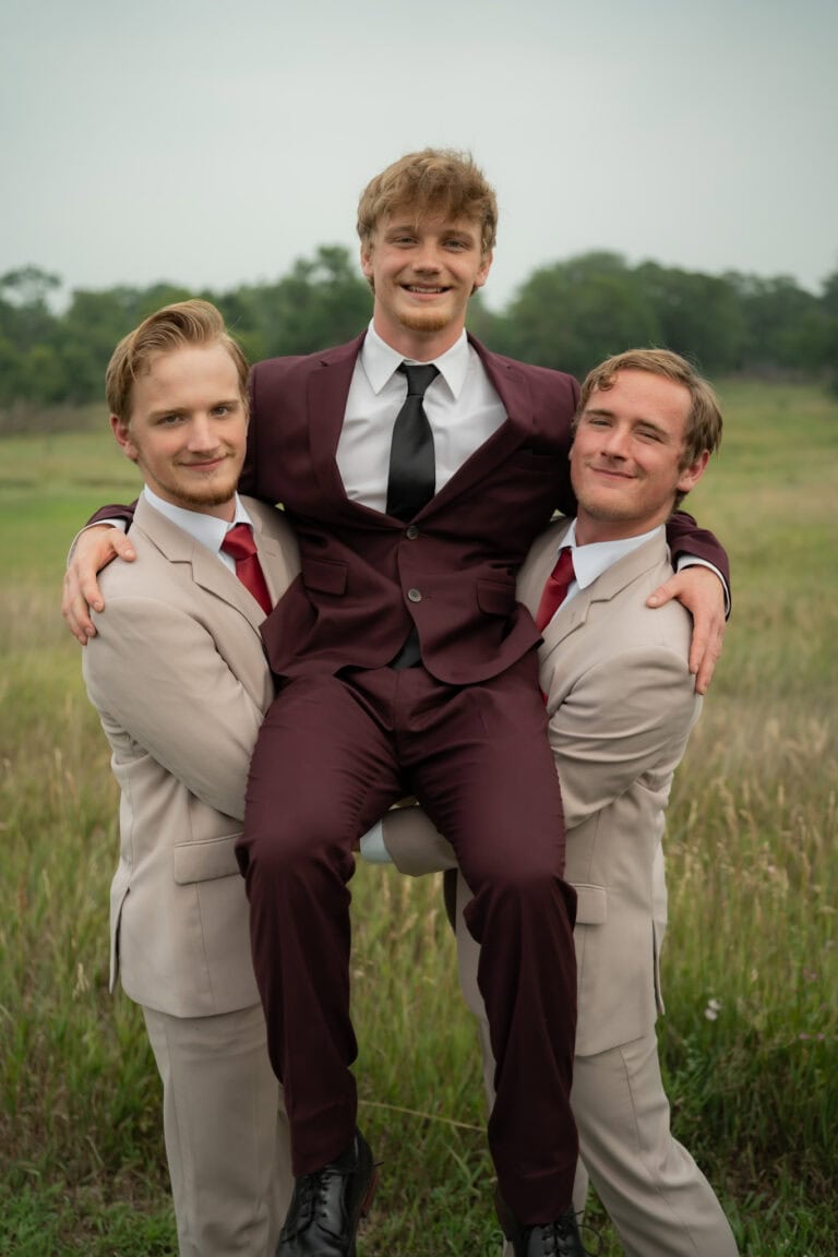 grooms wearing burgundy suit with groomsmen wearing tan