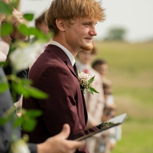 groom wearing burgundy suit