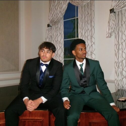 friends sitting at prom in tuxedos