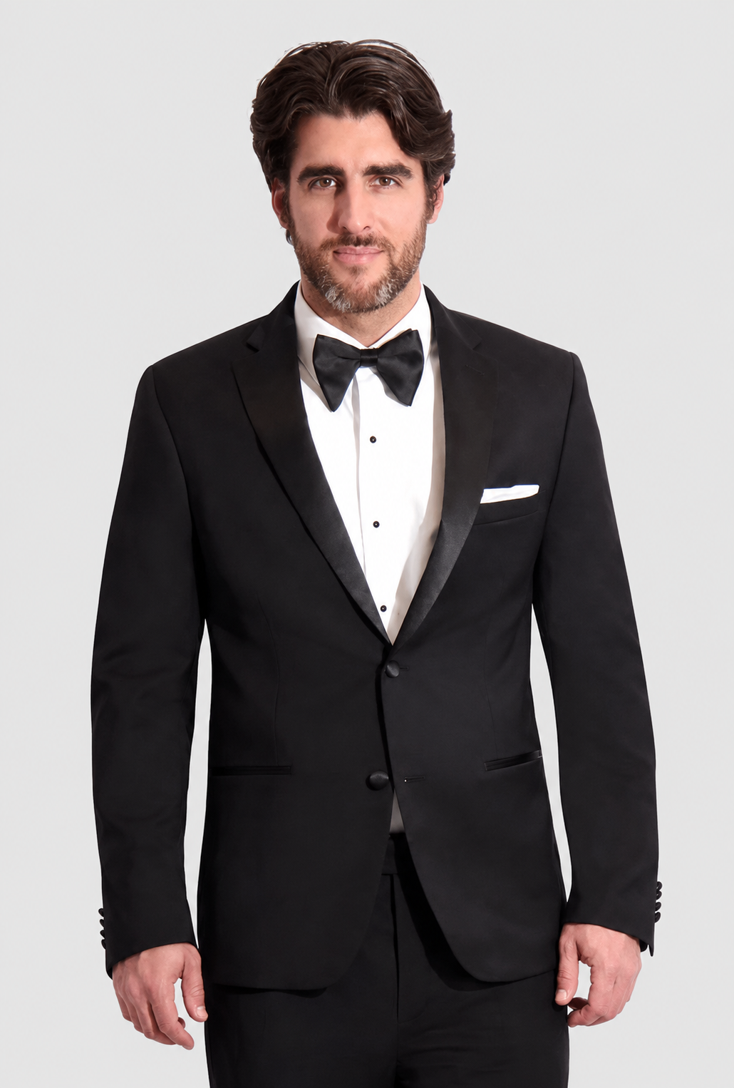 ntr-grey-20261007-5572-8708b31b6cb6 | National Tuxedo Rentals Man wearing a black tuxedo with bow tie and white pocket square, posing against a light background.