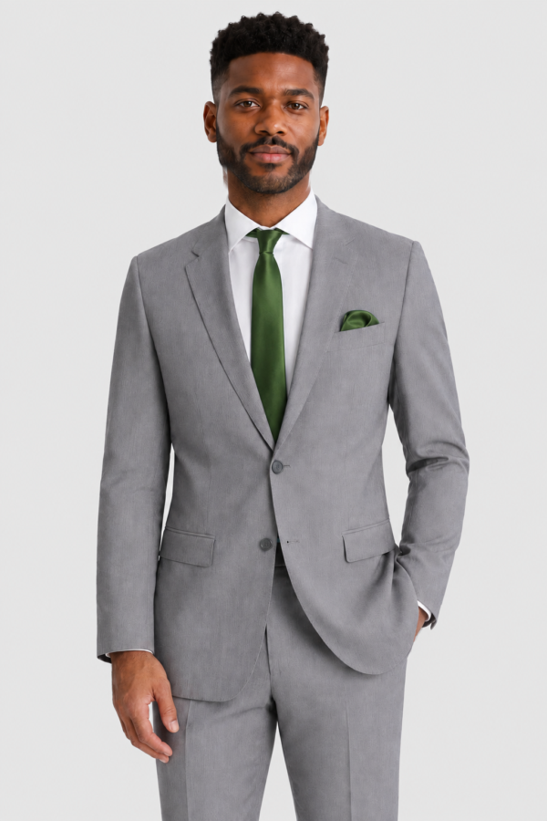 ntr-grey-20261007-5814-8dc4a81a3b1e | National Tuxedo Rentals Man in a light gray suit with a green tie, standing against a light background.
