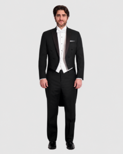 Man in a black tuxedo with a white waistcoat and bow tie, tails visible, standing against a light background.